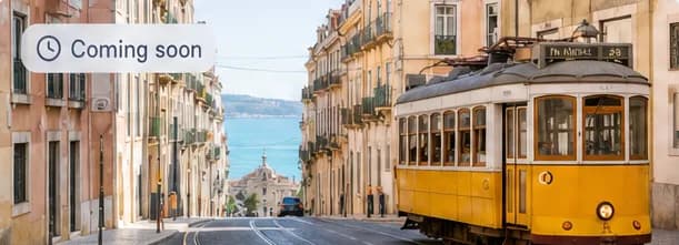 A yellow tram on a street in Lisbon